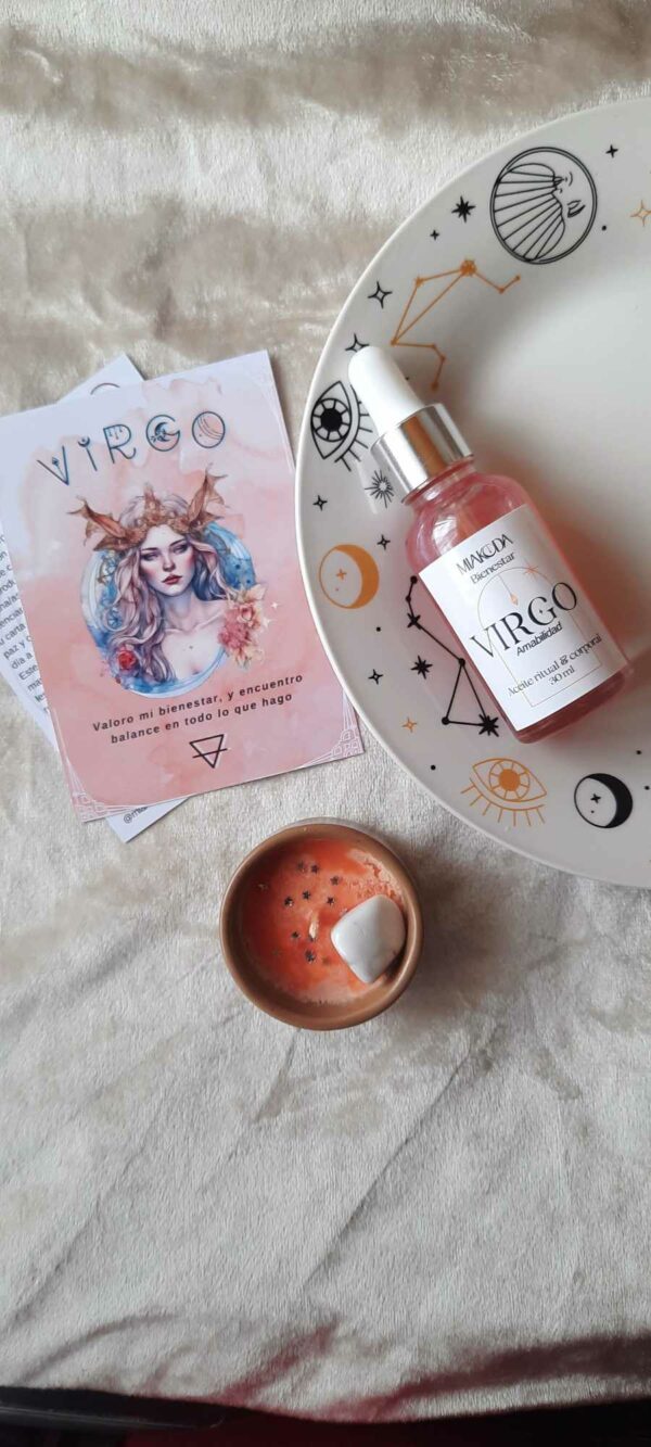 imagen de aceite colorido, mini vela anaranjada de soya y folleto con imagen de bella mujer en acuarela. Aceite sobre un plato blanco con diseño astrológico