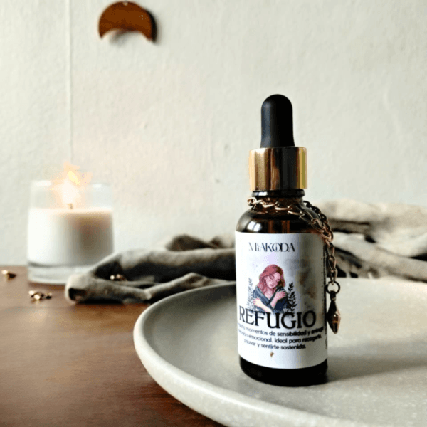 Aceite esencial Miakoda 'REFUGIO' en frasco decorado, con luz de vela y decoración esotérica, perfecto para el autocuidado.