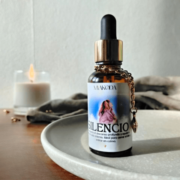 Frasco de aceite esencial Miakoda 'SILENCIO' con etiqueta artística, junto a una vela encendida, enfocado en el descanso profundo.